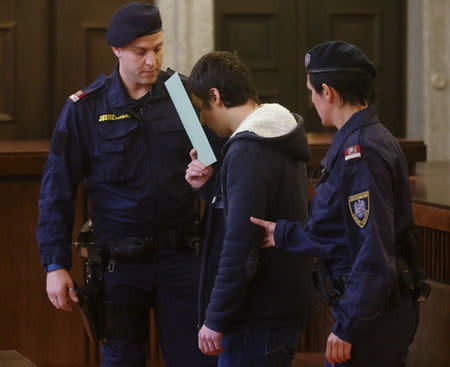 A 14-year-old terror suspect, who has been accused of preparing to join militant fighters in Syria and researching how to build a bomb, is led into court by prison guards in St. Poelten, Austria, May 26, 2015. REUTERS/Heinz-Peter Bader