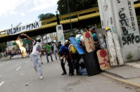 Demonstrators clash with riot security forces while rallying against Venezuela's President Nicolas Maduro's government in Caracas, Venezuela. The banner on the bridge reads "It will be worth it" . REUTERS/Ueslei Marcelino