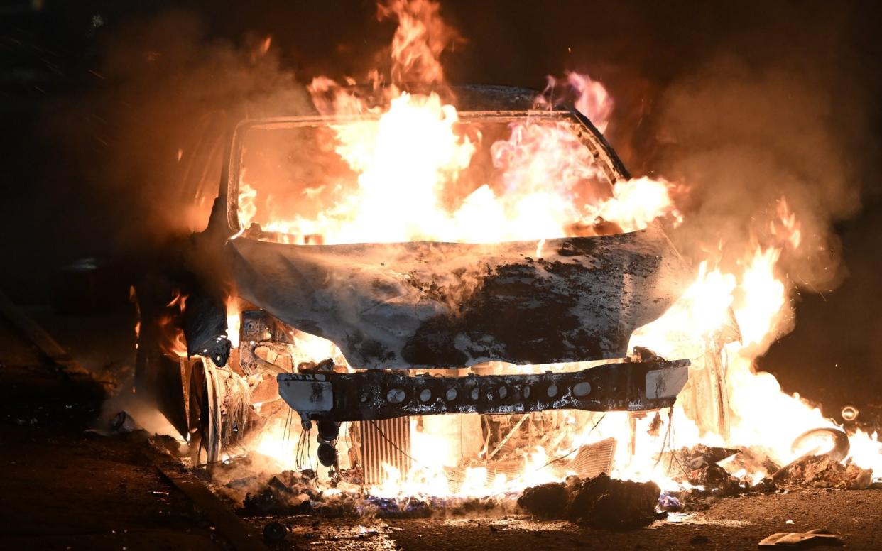 A torched car on Highmead Road in Ely - GETTY IMAGES