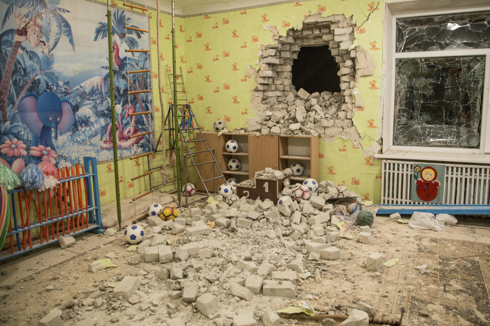 Bricks and debris mixes with toys below a damaged wall after the reported shelling on a kindergarten in the settlement of Stanytsia Luhanska, Ukraine Thursday late, Feb. 17, 2022. UU.S. President Joe Biden sounded unusually dire Thursday, as he warned that Washington saw no signs of a promised Russian withdrawal — but instead saw more troops moving toward the border with Ukraine, indicating Moscow could invade within days. (AP Photo/Oleksandr Ratushniak)