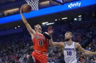 Chicago Bulls guard Zach LaVine (8) lays up the ball past Sacramento Kings forward Domantas Sabonis (10) during the first quarter of an NBA basketball game in Sacramento, Calif., Sunday, Dec. 4, 2022. (AP Photo/Randall Benton)