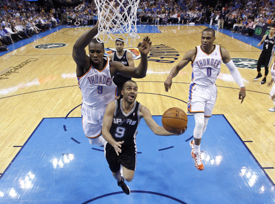 San Antonio Spurs guard Tony Parker (9) goes up for a shot in front of Oklahoma City Thunder forward Serge Ibaka (9) and guard Russell Westbrook (0) during the second quarter of an NBA basketball game in Oklahoma City, Thursday, April 3, 2014. Oklahoma City won 106-94. (AP Photo/Sue Ogrocki)