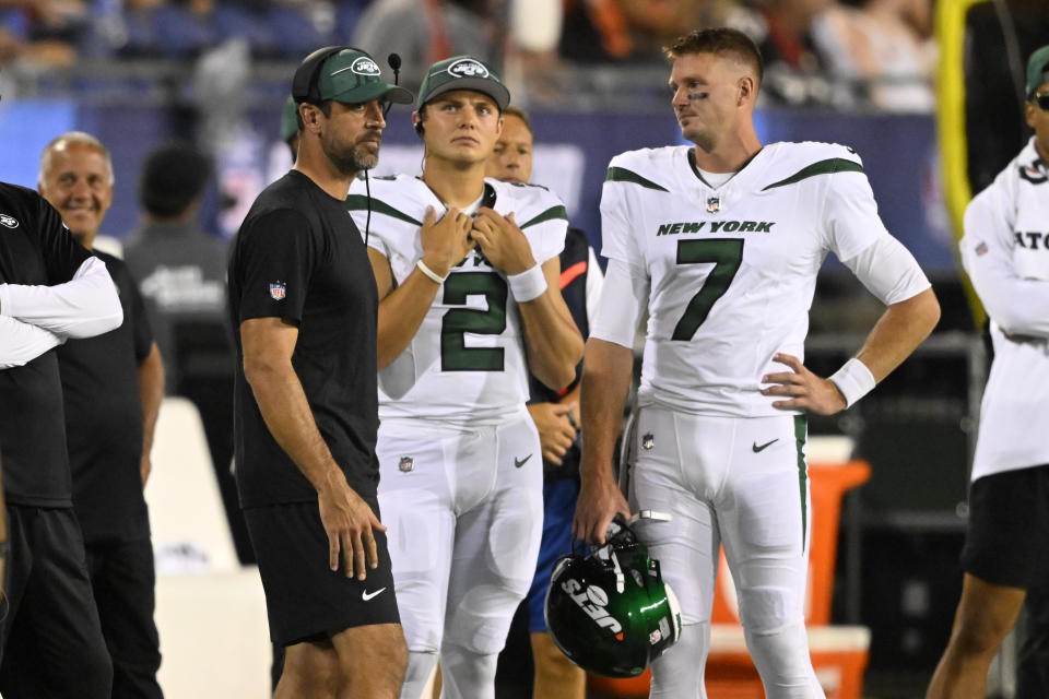 New York Jets quarterbacks Aaron Rodgers, Zach Wilson (2) and Tim Boyle (7) stand on the sideline after about half the lights at the stadium went out during the second half of the team's Hall of Fame NFL football preseason game against the Cleveland Browns on Thursday, Aug. 3, 2023, in Canton, Ohio. (AP Photo/David Richard)