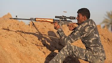 A Shi'ite fighter aims using a sniper rifle during a patrol in Jurf al-Sakhar. Photo: Reuters