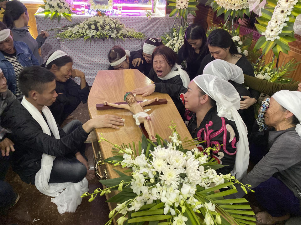 Relatives of Bui Thi Nhung weep as they gather around Nhung's casket at the family home on Saturday, Nov. 30, 2019 in the village of Do Thanh, Vietnam. The body of 19-year old Nhung was among the last remains of the 39 Vietnamese who died while being smuggled in a truck to England last month that were repatriated to their home country on Saturday. (AP Photo/Hau Dinh)