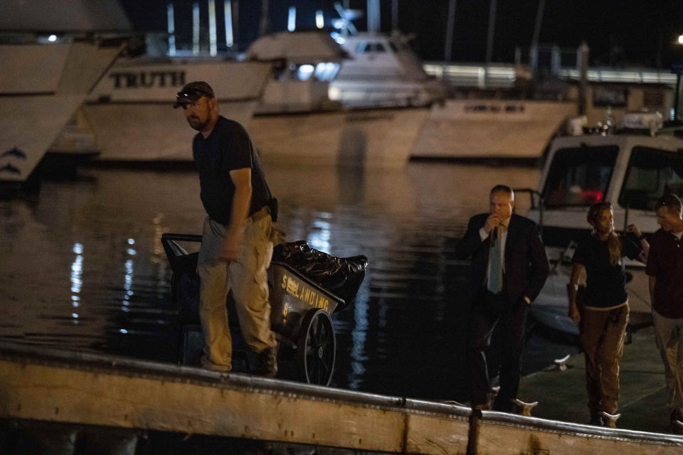 Authorities cart away evidence taken from the scuba boat Conception in Santa Barbara Harbor at the end of their second day searching for the remaining divers who were missing on Tuesday, Sept. 3, 2019, in Santa Barbara, Calif. High school students, a science teacher and his daughter, an adventurous marine biologist and a family of five celebrating a birthday are among those presumed to have died when fire tore through a scuba diving boat off the Southern California coast Monday, trapping dozens of sleeping people below deck. (AP Photo/Christian Monterrosa)