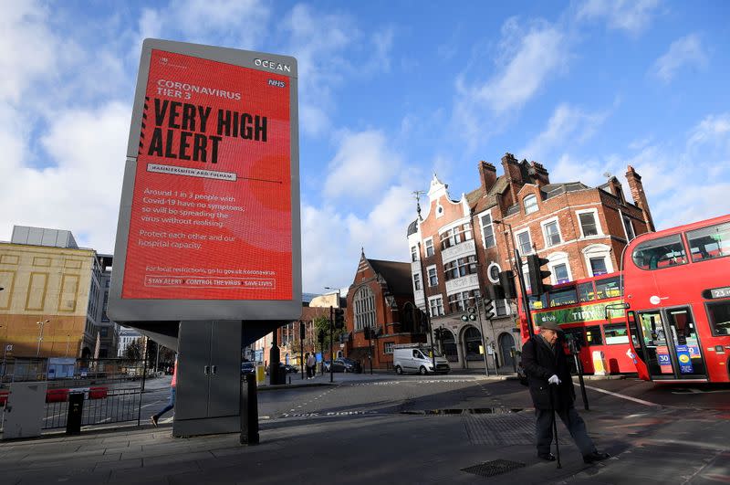 Pedestrians walk past a British government health information advertisement highlighting new restrictions amid the spread of the coronavirus disease (COVID-19), London, Britain