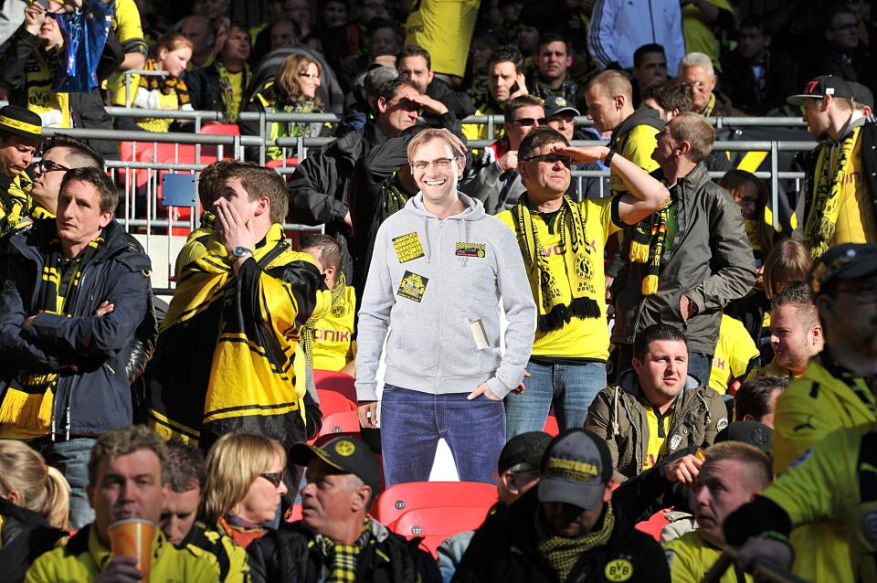 Borussia Dortmund fans in the stands with a cardboard cut out of manager Jurgen Klopp