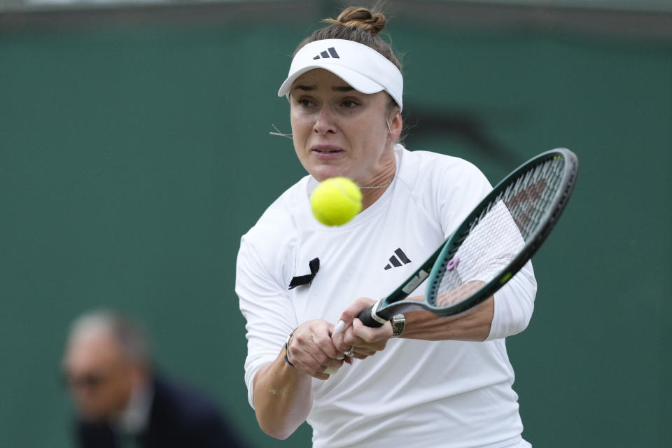 Elina Svitolina of Ukraine plays a backhand return to Xinyu Wang of China during their fourth round match at the Wimbledon tennis championships in London, Monday, July 8, 2024. (AP Photo/Mosa'ab Elshamy)