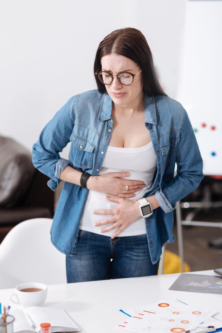 She was having horrible menstrual cramps one day at work so she took out hot water bottle and nestled it in her lap.<em> (Photo: Getty)</em>