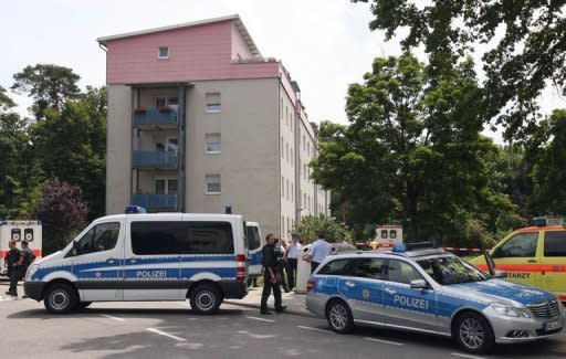 Police stand in front of the house where a gunman had taken several people hostage in Karlsruhe, southwestern Germany. A police spokesman said the hostage-taker and all his hostages were dead after he barricaded himself and them into an apartment block