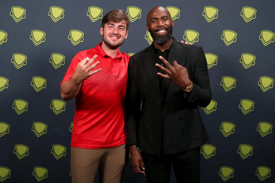 Upper Arlington's Sam Burns and guest speaker Malcolm Jenkins both hold up three fingers in honor of the three awards Burns received at the Central Ohio High School Sports Awards. Burns was named overall Male Athlete of the Year and earned Athlete of the Year honors for hockey and boys lacrosse.