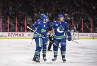 Vancouver Canucks' J.T. Miller, front left, Jake Virtanen, right, and Jake Virtanen, back left, celebrate Miller's first goal against the St. Louis Blues during the second period of an NHL hockey game in Vancouver, British Columbia on Monday Jan. 27, 2020. (Darryl Dyck/The Canadian Press via AP)