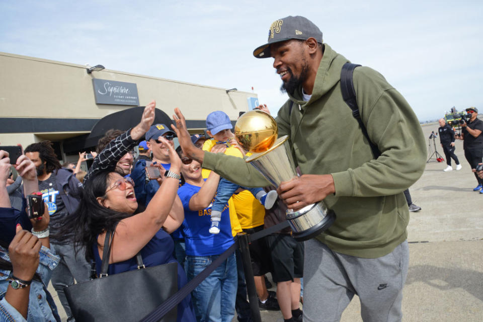 Kevin Durant high-fives fans after the Golden State Warriors return home following their Game 4 win over the Cleveland Cavaliers. (Getty)