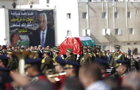 Palestinian honor guards carry a coffin containing the body of Palestinian minister Ziad Abu Ein during his funeral in the West Bank city of Ramallah December 11, 2014. REUTERS/Mohamad Torokman