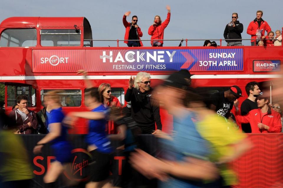 Support: Sir Richard Branson waves off runners after starting the half marathon (PA)