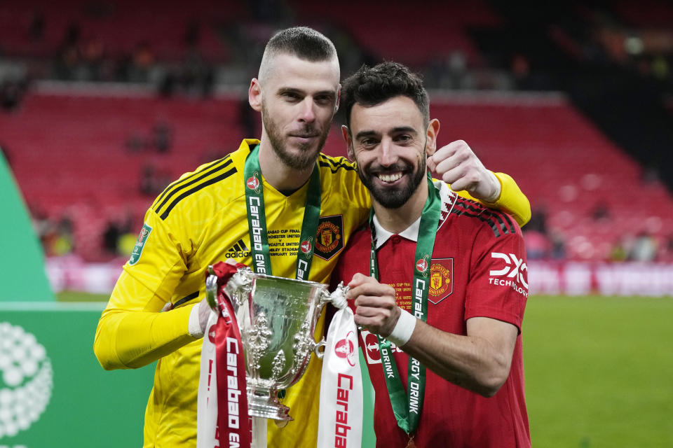 Manchester United's Bruno Fernandes, right, and goalkeeper David de Gea pose with the trophy after the English League Cup final soccer match between Manchester United and Newcastle United at Wembley Stadium in London, Sunday, Feb. 26, 2023. (AP Photo/Alastair Grant)