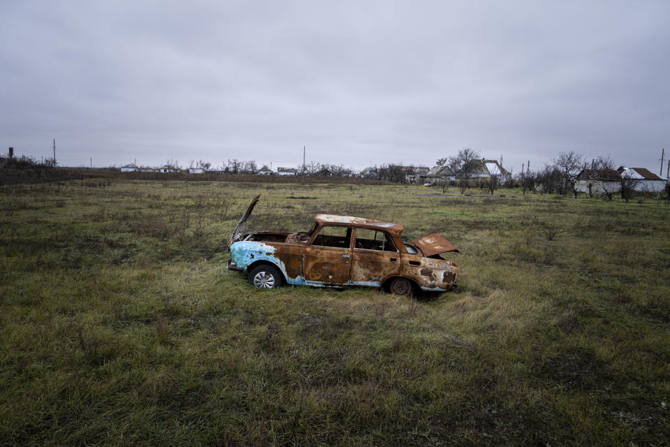 A car destroyed by Russian shelling sits in a field in Posad-Pokrovske village, in the Kherson region, Ukraine, Friday, Dec. 2, 2022. (AP Photo/Evgeniy Maloletka)