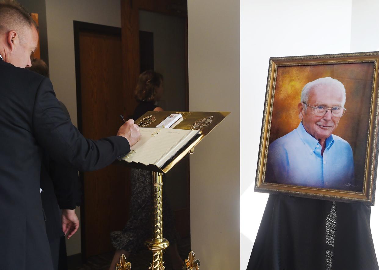 A guest signs the registry before the service of Christian burial for Paul Nelson, right, at St. Mark's Episcopal Church in Millcreek Township on May 31. Nelson, owner of Waldameer Park & Water World, died May 21 at age 89.