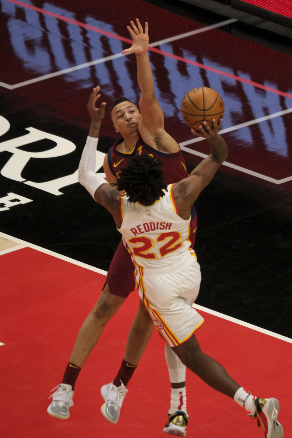 Atlanta Hawks forward Cam Reddish (22) tries for a shot and is blocked by Cleveland Cavaliers guard Dante Exum (1) during the second half of an NBA basketball game on Saturday, Jan. 2, 2021 in Atlanta. (AP Photo/Ben Gray)