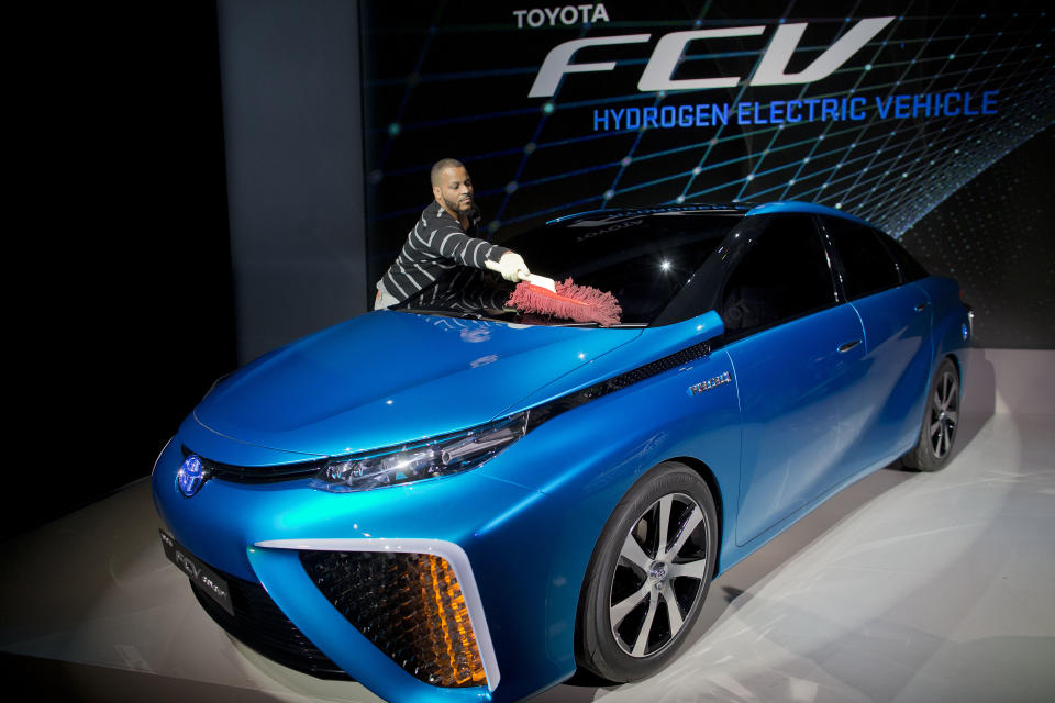 A production crew member dusts off Toyota's FCV hydrogen electric concept car during the International Consumer Electronics Show, Monday, Jan. 6, 2014, in Las Vegas. Toyota announced the car would be available to consumers in 2015. (AP Photo/Julie Jacobson)