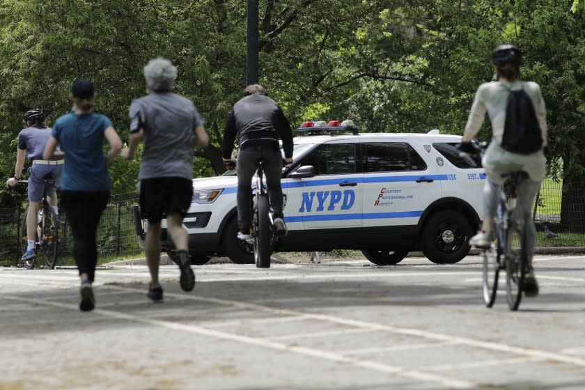 Runners and cyclists pass a New York Police vehicle People in Central Park during the coronavirus pandemic, Saturday, May 16, 2020, in New York. (AP Photo/Frank Franklin II)