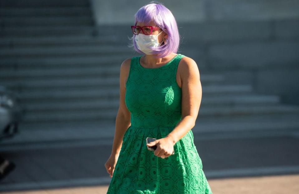 Kyrsten Sinema wears a purple wig and green dress