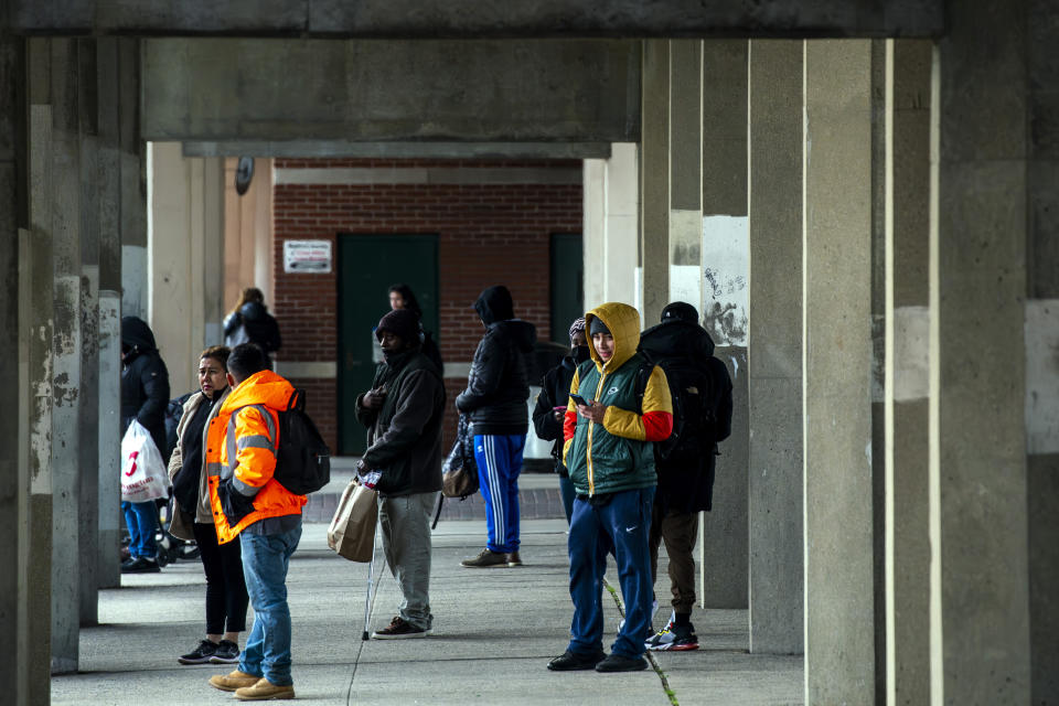 People wait for a bus near the train station, Tuesday, March 26, 2024, in Freeport, N.Y. In Long Island's Nassau County, a handful of Latino residents and a local civil rights organization allege that a redistricting map drawn by the county Legislature dilutes the voting power of Black, Latino and Asian residents. (AP Photo/Eduardo Munoz Alvarez)