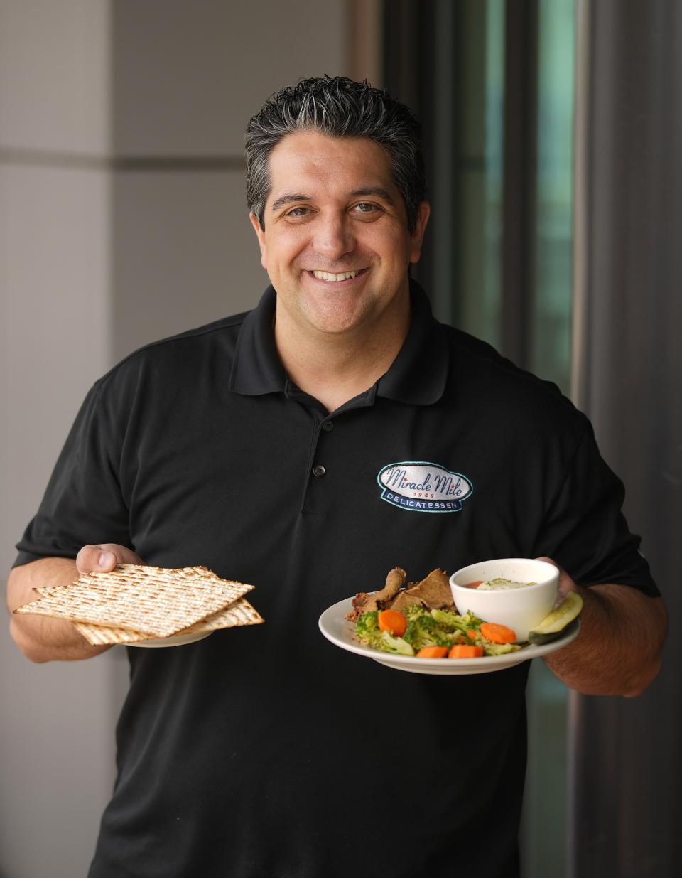 Miracle Mile Deli owner Josh Garcia poses for a picture on March 30, 2023, with his Passover Special dish at the family-owned restaurant.