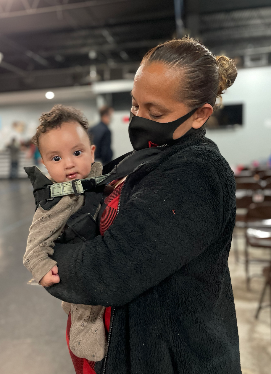 A mother carried her baby as she waited in line for fresh clothes at the Catholic Charities of the Rio Grande Valley Humanitarian Respite Center. / Credit: Natacha Larnaud