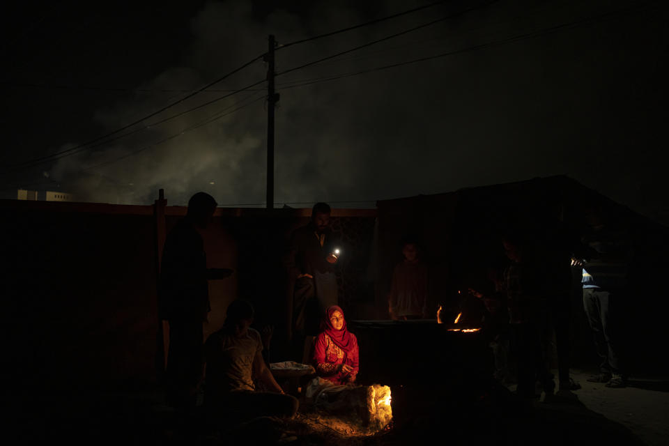 Palestinians displaced by the Israeli bombardment of the Gaza Strip cook at the makeshift tent camp in the Muwasi area on Sunday, Dec. 31, 2023. Israel has encouraged Palestinians to move to Muwasi, telling them they will be safe from bombing. (AP Photo/Fatima Shbair)