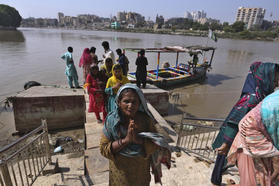 People from Pakistani Hindu community arrives to visit at the Sadhu Bela temple, located in an island on the Indus River, in Sukkur, Pakistan, Wednesday, Oct. 26, 2022. On the banks of the Indus River, which flows through Pakistan and into its southern Sindh province, Hindus wait for brightly colored boats to ferry them to an island that has housed Sadhu Bela temple for almost 200 years. The island was gifted to the Hindu community by wealthy Muslim landlords in Sindh, an unthinkable act in modern-day Pakistan. (AP Photo/Fareed Khan)