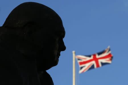 A Union Flag is seen behind a statue of Britain's former Prime Minister Winston Churchill in London January 24, 2015. REUTERS/Luke MacGregor