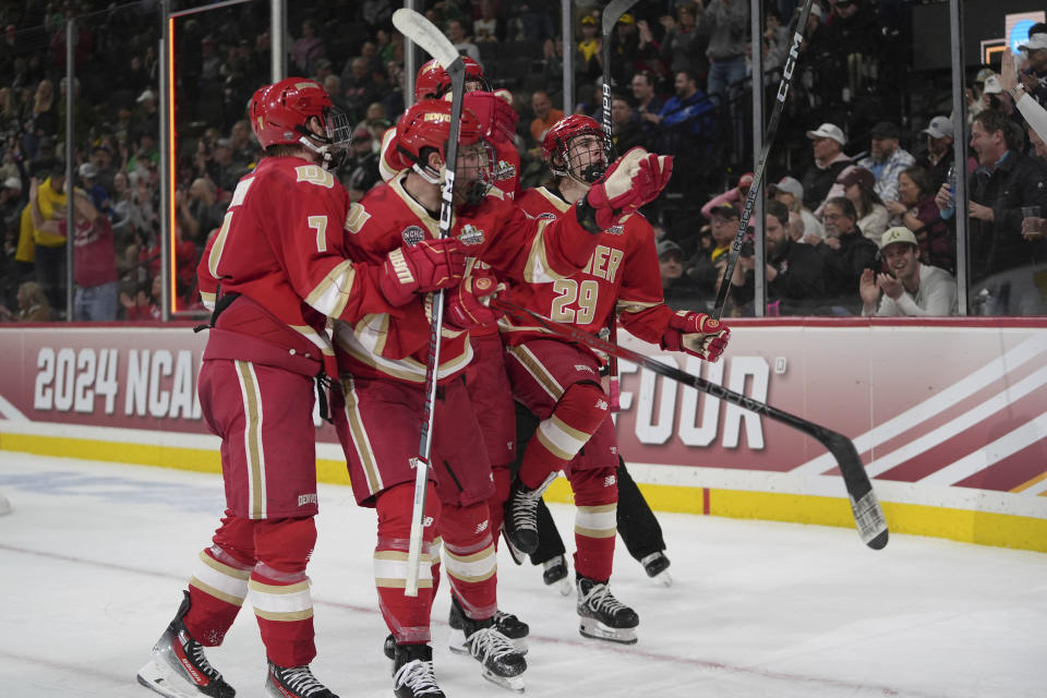 Denver forward Tristan Lemyre (29) celebrates with teammates after scoring during the second period of a semifinal game against Boston University at the Frozen Four NCAA college hockey tournament Thursday, April 11, 2024, in St. Paul, Minn. (AP Photo/Abbie Parr)