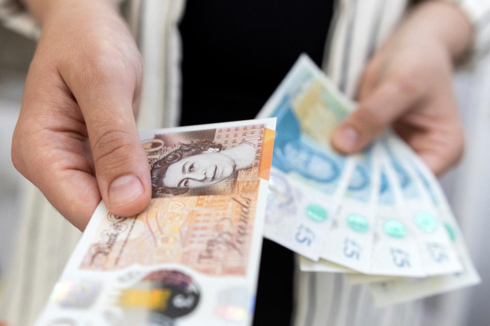 UK bank Woman holds British Pound banknotes in this illustration taken May 30, 2022. REUTERS/Dado Ruvic/Illustration