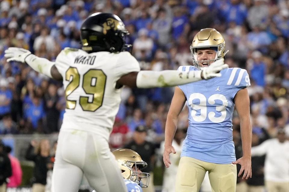 Colorado's Rodrick Ward holds his arms up on his sides while UCLA's R.J. Lopez stands nearby.