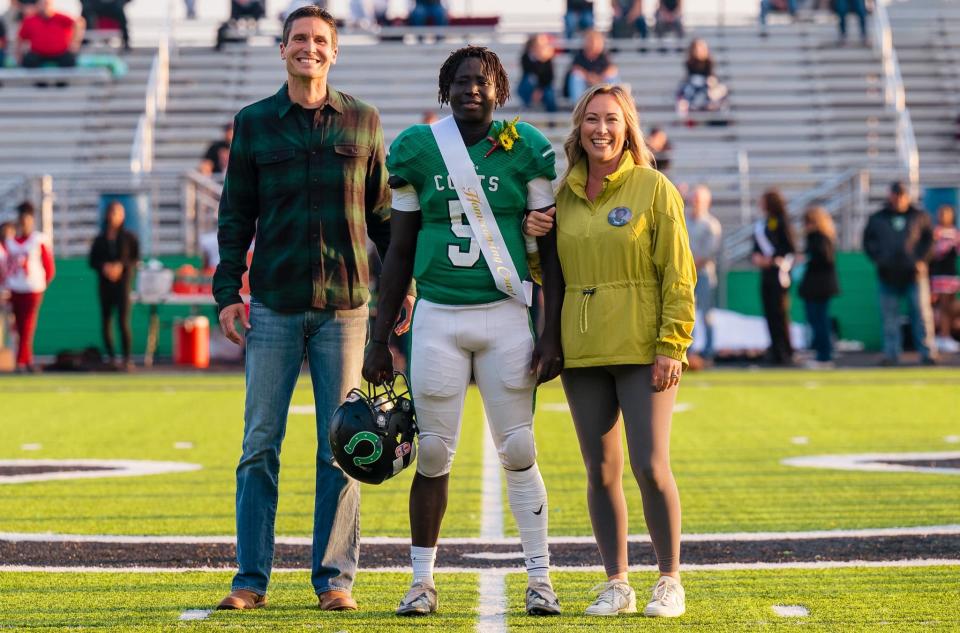 Clear Fork's Sengo Ault and his mother, Casey (right), and father, Micah (left), during homecoming festivities in September.