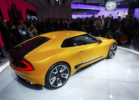 Members of the media crowd around the Kia GT4 Stinger concept car as it is displayed during the press preview day of the North American International Auto Show in Detroit, Michigan January 13, 2014. REUTERS/Joshua Lott