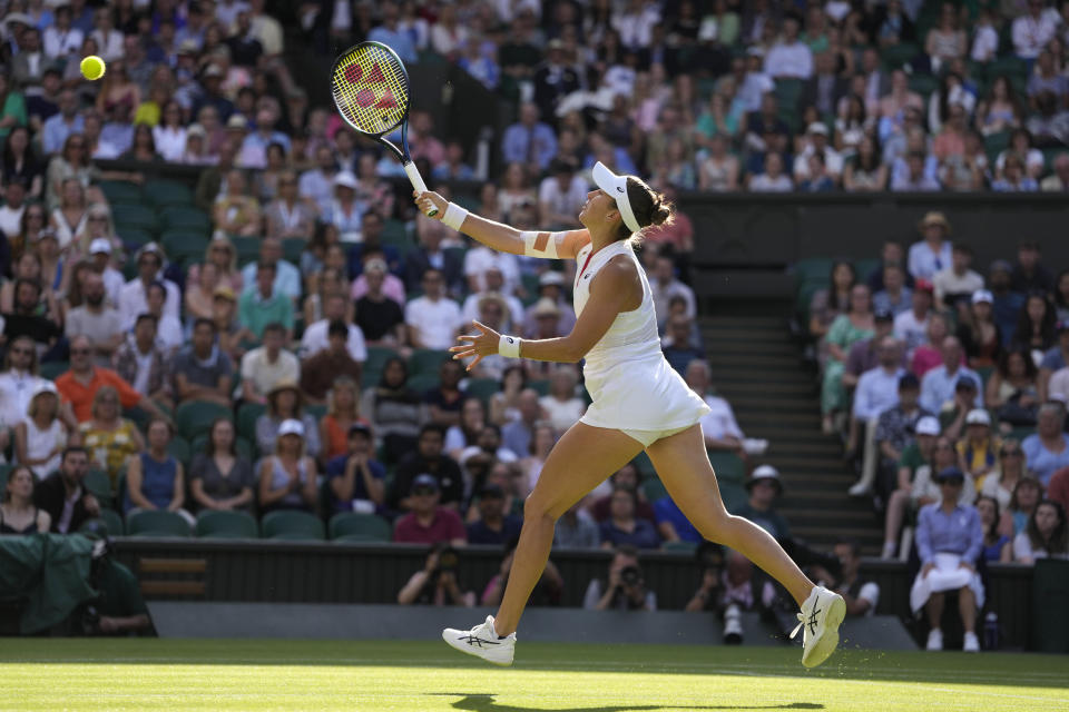Switzerland's Belinda Bencic returns to Poland's Iga Swiatek in a women's singles match on day seven of the Wimbledon tennis championships in London, Sunday, July 9, 2023. (AP Photo/Kirsty Wigglesworth)