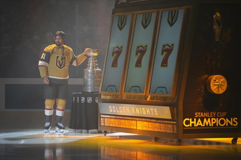Vegas Golden Knights right wing Mark Stone (61) stands by the Stanley Cup during a ceremony before an NHL hockey game against the Seattle Kraken, Tuesday, Oct. 10, 2023, in Las Vegas. (AP Photo/John Locher)