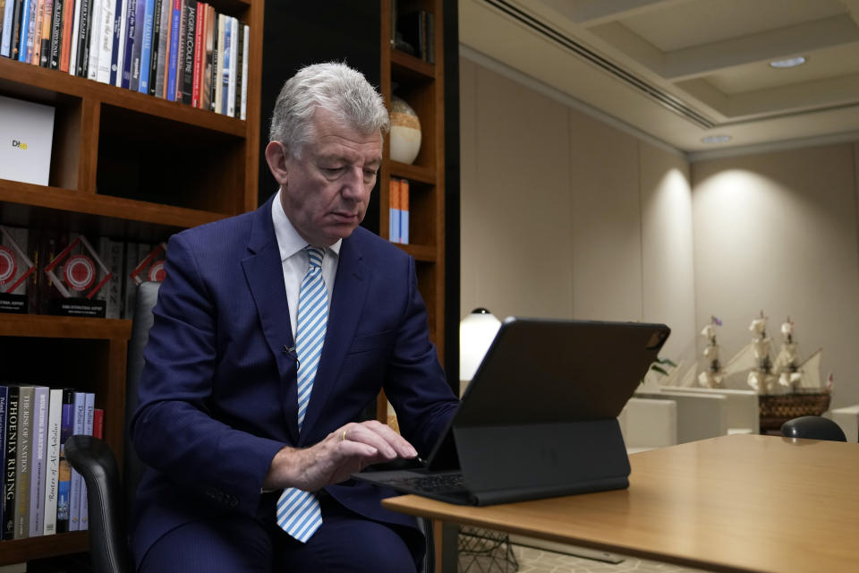 Paul Griffiths, the CEO of Dubai Airports, takes a look at his notes during an interview with The Associated Press in Dubai, United Arab Emirates, Tuesday, Nov. 22, 2022. Dubai International Airport passenger numbers surpassed pre-COVID-19 pandemic levels in the third quarter of 2022, Griffiths said, causing the airport to revise its annual forecast by another 1 million passengers. (AP Photo/Kamran Jebreili)