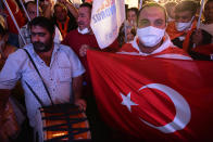 Supporters of the newly elected Turkish Cypriot leader Ersin Tatar hold a Turkish flag and celebrate winning, in the Turkish occupied area in the north part of the divided capital Nicosia, Cyprus, Sunday, Oct. 18, 2020. Ersin Tatar, a hardliner who favors even closer ties with Turkey and a tougher stance with rival Greek Cypriots in peace talks has defeated the leftist incumbent in the Turkish Cypriot leadership runoff. (AP Photo/Nedim Enginsoy)