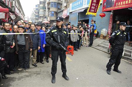 Police stand guard in front of local residents near a crime site on a street in Changsha, Hunan Province, March 14, 2014. Knife-wielding assailants attacked civilians in Changsha on Friday morning, leaving at least one person dead, according to Xinhua News Agency. REUTERS/China Daily