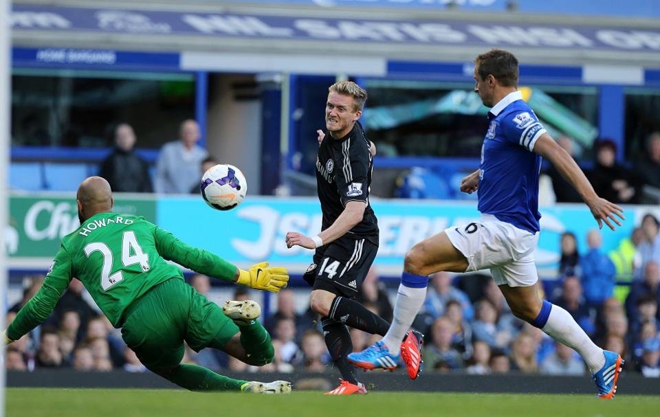 Chelsea's Andre Schurrle (centre) flicks the ball over Everton goalkeeper Tim Howard for an attempt on goal