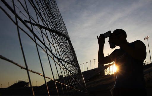 Photo illustration shows a man taking photos with his smartphone. The impact of the new restrictions in China's already heavily regulated cyberspace remains to be seen, with mainland filmmakers having come to see the micro movies as a haven from box-office pressure and a means of artistic release