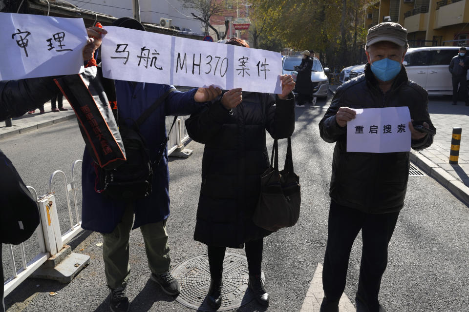 Relatives of passengers on the missing MH370 hold up a banner which reads "trial of the Malaysian MH370 case" and "Restart Search" in Beijing, Monday, Nov. 27, 2023. A Beijing court is holding compensation hearings for Chinese relatives of people who died on a Malaysia Airlines plane that disappeared in 2014 on a flight to Beijing. (AP Photo/Ng Han Guan)