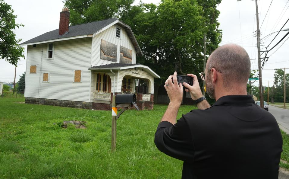 City of Columbus code enforcement officer Matthew Mercer examines a house with multiple violations at 794 Renick St. on the West Side. He said once a house is boarded up, every window, door and opening must be fully boarded and painted.