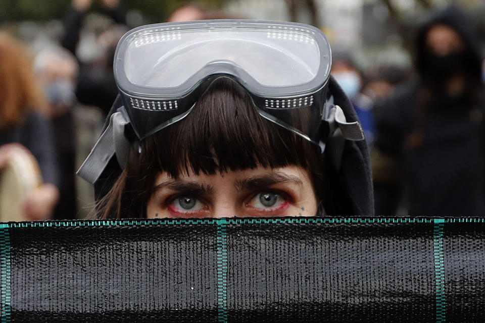 A protestor with a diving mask on her head, holds a banner during a protest in the capital Nicosia, on Saturday, Feb. 20, 2021, against the corruption within the country's politicians, as well as fatigue over restrictions to curb COVID-19 infections. The demonstration that drew an estimated 3,000 people came a week after police were strongly criticized for resorting to disproportionate force by using a water canon, stun grenades and pepper spray to disperse a crowd of a few hundred left-wing protesters voicing their opposition to corrupt politicians. (AP Photo/Petros Karadjias)