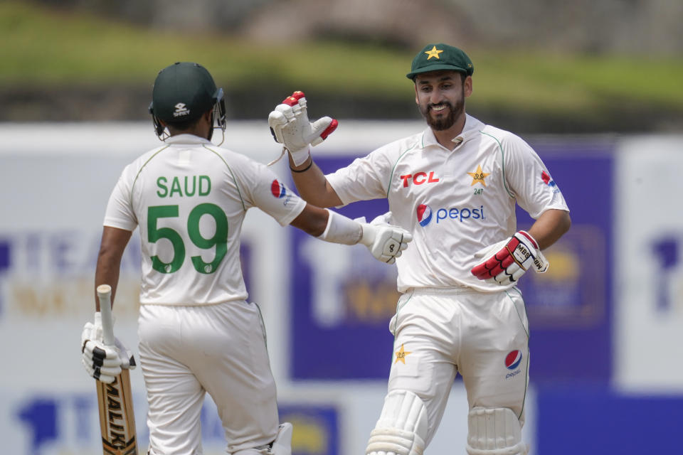 Pakistan's Agha Salman, right, congratulates Saud Shakeel for scoring a century during the third day of the first cricket test match between Sri Lanka and Pakistan in Galle, Sri Lanka, on Tuesday, July 18, 2023. (AP Photo/Eranga Jayawardena)