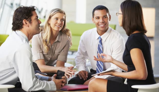 Businesspeople With Digital Tablet Having Meeting In Office